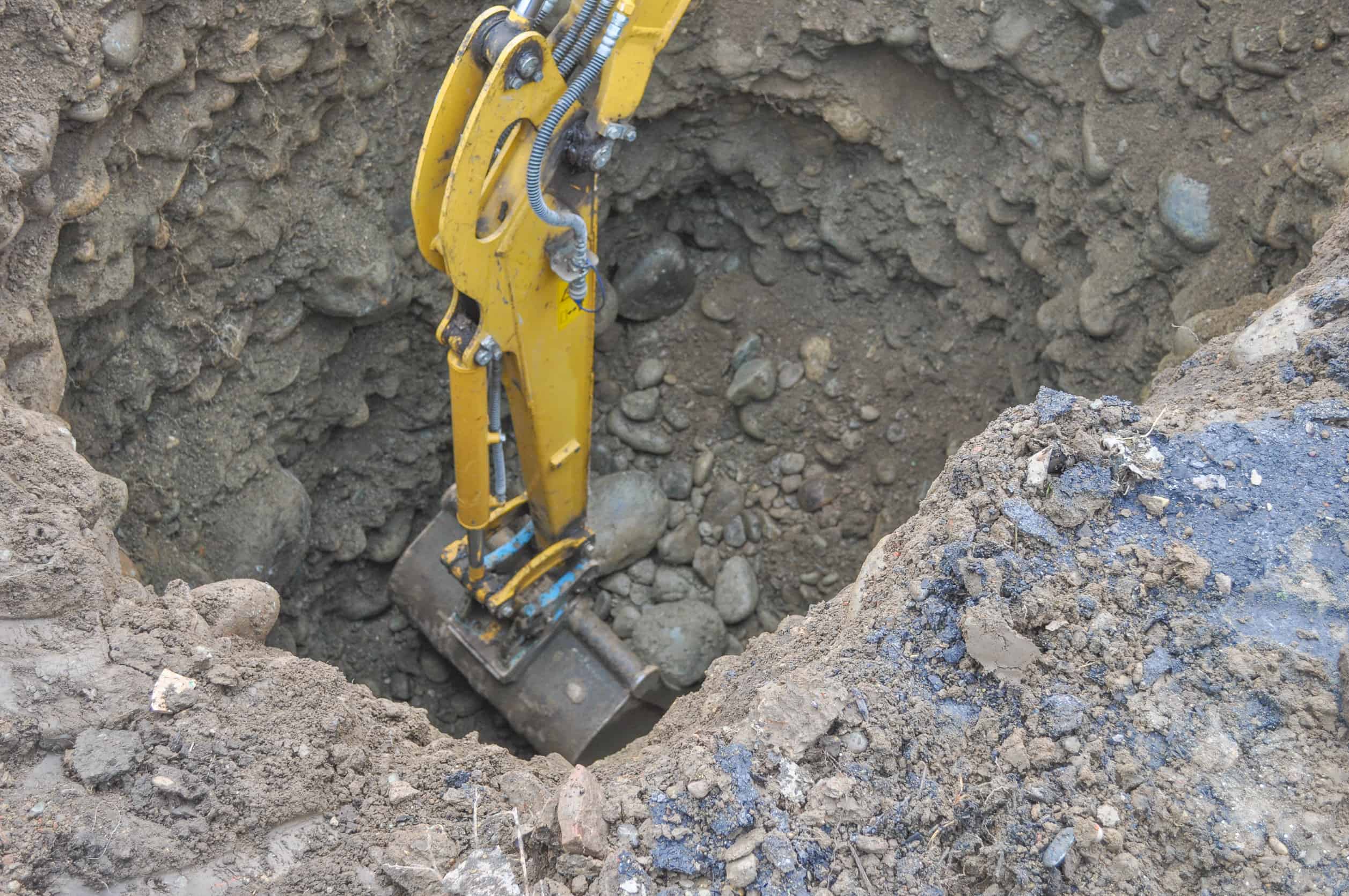 Excavator mechanical shovel digger digging a hole in the ground